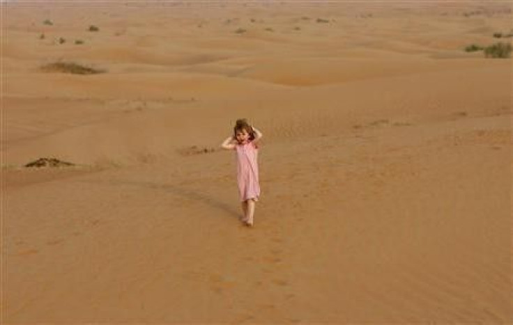 A tourist walks in the Dubai desert