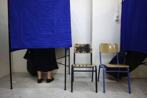 Woman stands in voting booth at an Athens polling station during Greece&#039;s national election