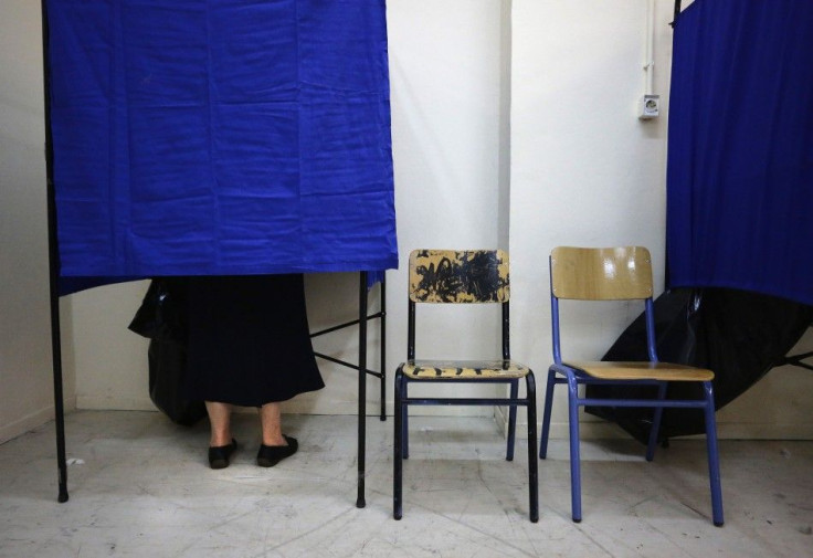 Woman stands in voting booth at an Athens polling station during Greece&#039;s national election