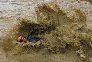A zombie lands in a pool of water on the &quot;Run for Your Lives&quot; 5K obstacle course race in Amesbury