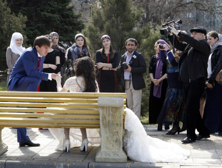 A bride and groom pose near the shores of the Caspian sea as part of their wedding day celebrations in the Dagestan capital of Makhachkala