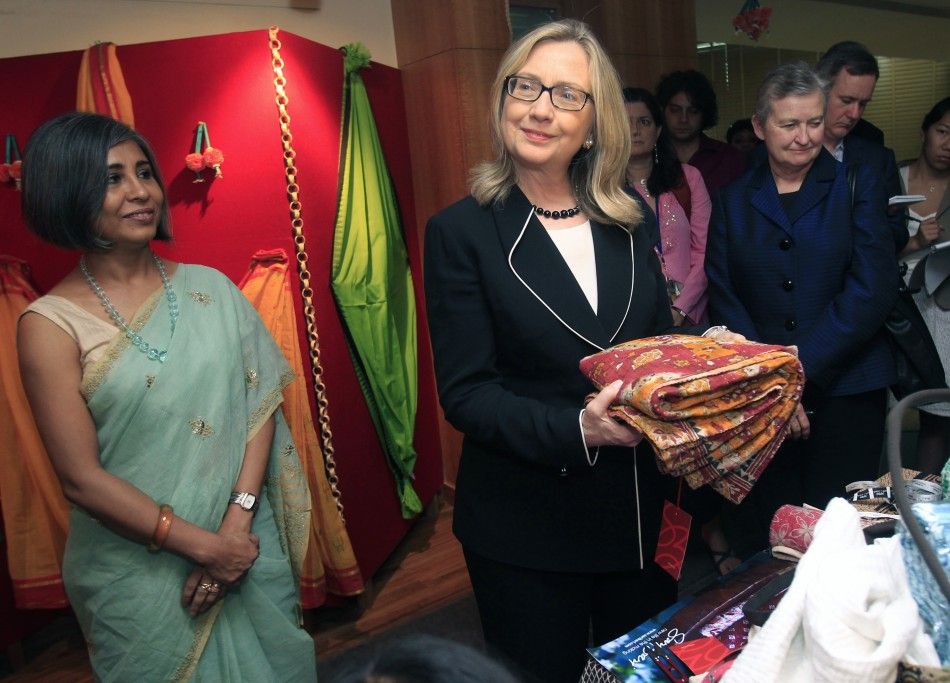 U.S. Secretary of State Hillary Clinton 2nd L holds a sari during an anti-human trafficking event in Kolkata May 6, 2012.