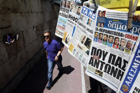 A man walks past a kiosk selling newspapers in central Athens. A trade credit crunch is threatening to affect the supply of foreign goods into that country.