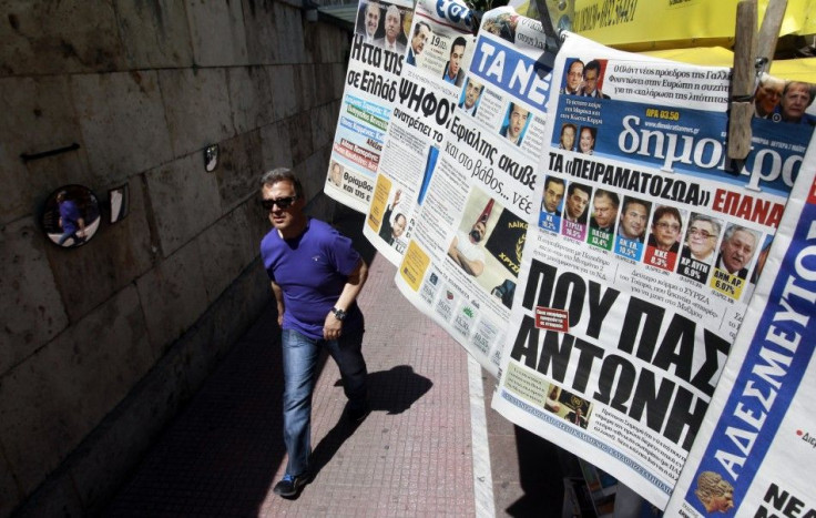 A man walks past a kiosk selling newspapers in central Athens. A trade credit crunch is threatening to affect the supply of foreign goods into that country.