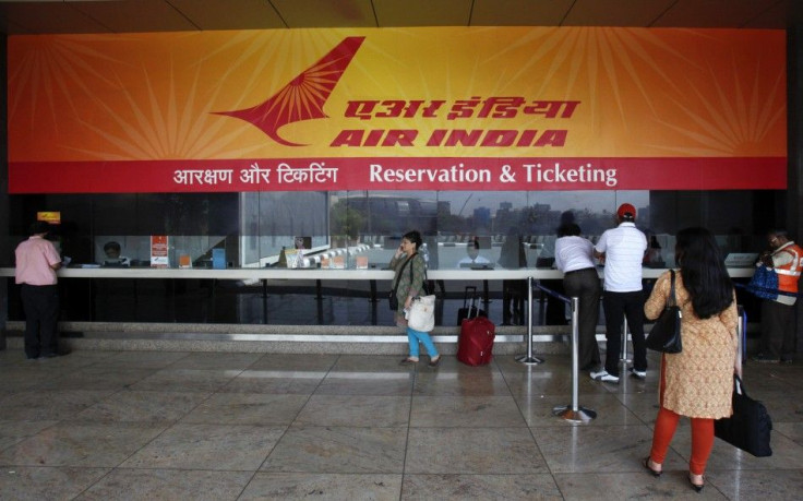 Customers stand at an Air India reservation office at domestic airport in Mumbai