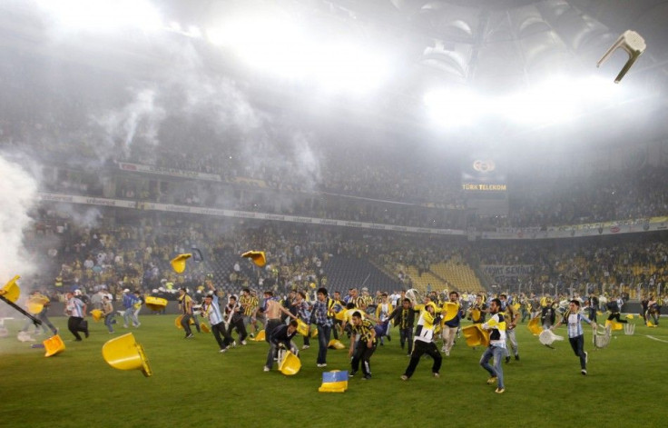 Fenerbahce fans invaded the pitch and threw plastic chairs and flares at police and Galatasary players.