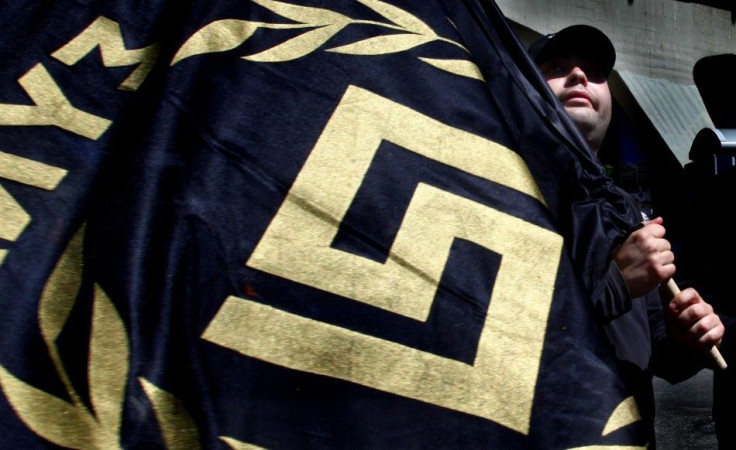 Member of Greece's extreme-right Golden Dawn party holds flag bearing party logo during election campaign rally in Athens