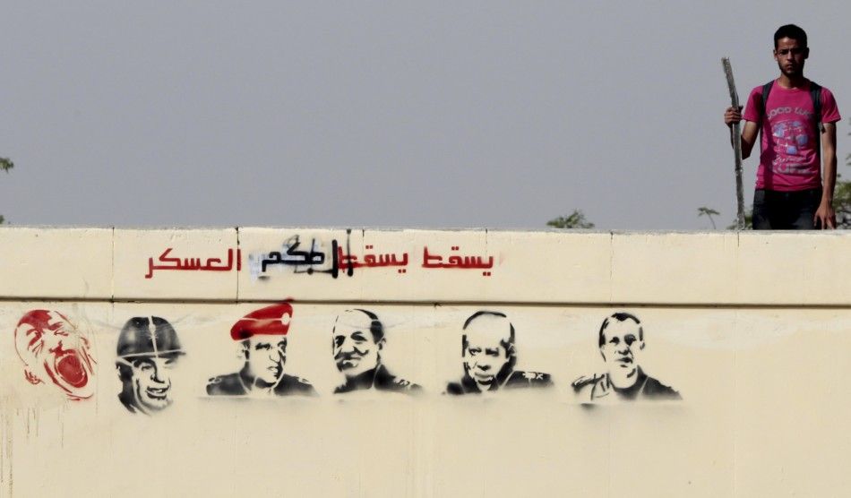 An Egyptian anti-military protester takes his position on a bridge with stencilled paintings depicting the Egyptian military council members, at Abbasiya Square in Cairo May 2, 2012. Egypt039s military might hand over to civilian rule earlier than plan