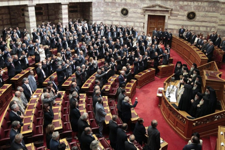 Newly appointed lawmakers raise their arms during a swearing in ceremony in Athens