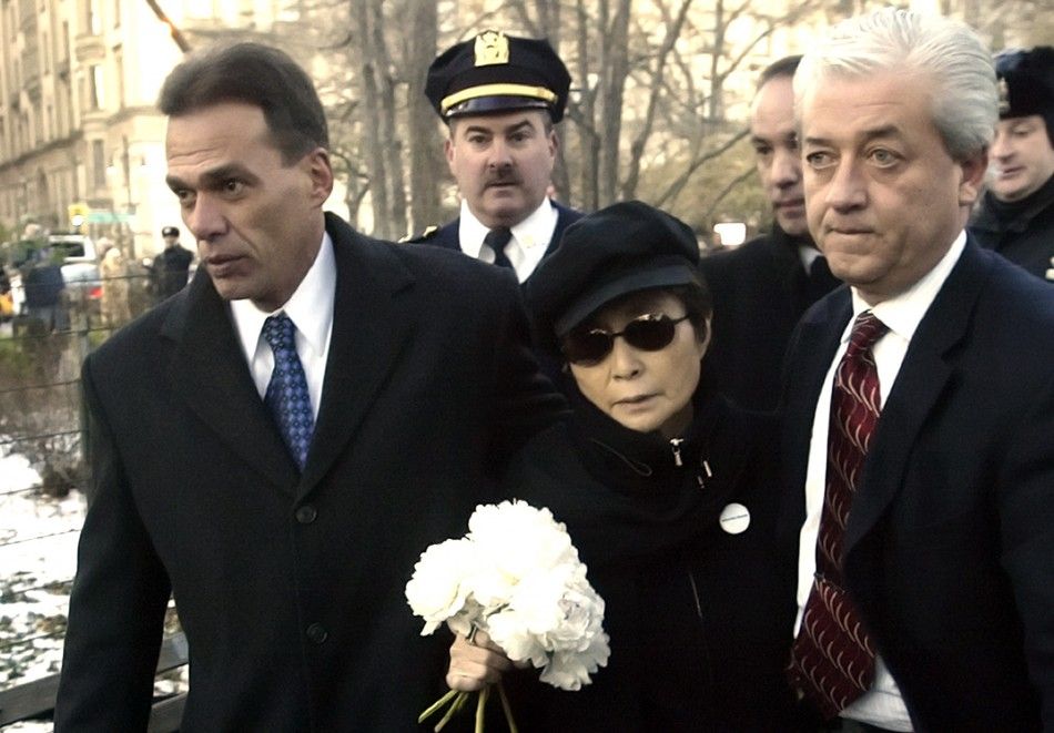 Yoko Ono C is escorted by police officers to a memorial to honor her deceased husband John Lennon in Central Parks Strawberry Fields in New York December 8, 2005.