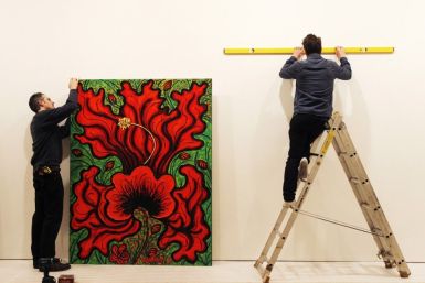 Technicians hang artist Ana Tzarev's painting &quot;Love (Hibiscus)(Garden La Fleur du Cap)&quot; at the Saatchi Gallery in London May 17, 2012. Thione hopes his Artify It service will mark a major departure from the traditional gallery setting 