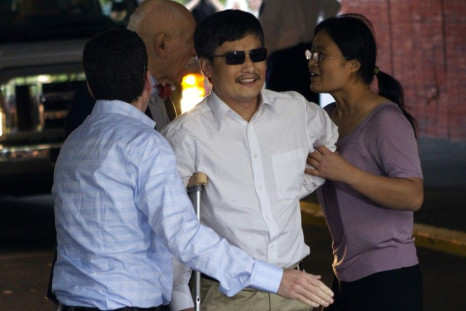 Blind Chinese dissident Chen Guangcheng (C) is helped by his wife Yuan Weijing (R) after arriving in New York May 19, 2012.