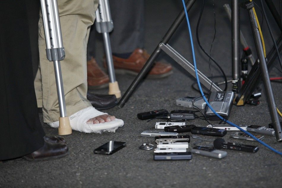 The injured foot of blind Chinese dissident Chen is pictured next to recording equipment from the media as he speaks during his arrival in New York