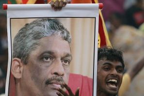 A supporter of Ex-General Sarath Fonseka holds up a banner with his image in-front of the Welikada prison as he waits for Fonseka in Colombo