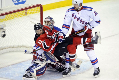 Rangers&#039; Stralman upends Devils&#039; Gionta in front of Rangers&#039; Lundqvist during the third period in game 3 of their NHL Eastern Conference Final hockey playoff game