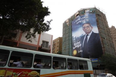A bus passes by a giant campaign poster of presidential candidate Amr Moussa in Cairo