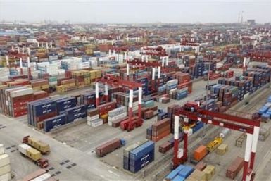 Trucks are driven into a shipping container area at Qingdao port