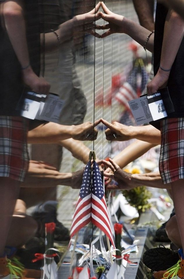 People touch the Vietnam Veterans Memorial wall, etched with the names of more than 58,000 U.S. servicemen and women who died in the war, as they visit on Memorial Day weekend in Washington, May 27, 2012.