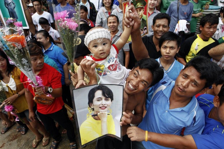 Migrant workers from Myanmar hold a picture of pro-democracy leader Suu Kyi and flowers in Samut Sakhon province