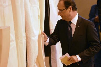 France's President Hollande enters the voting both in the legislative elections at the polling station in Tulle