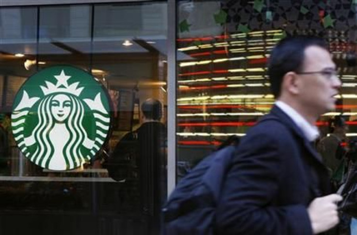 A pedestrian walks past the new Starbucks logo on a store in Times Square in New York