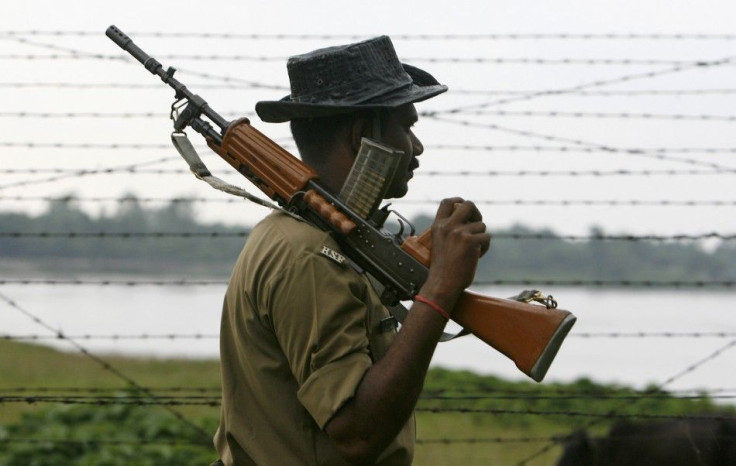 Indian BSF soldier keeps watch along the fenced border with Bangladesh