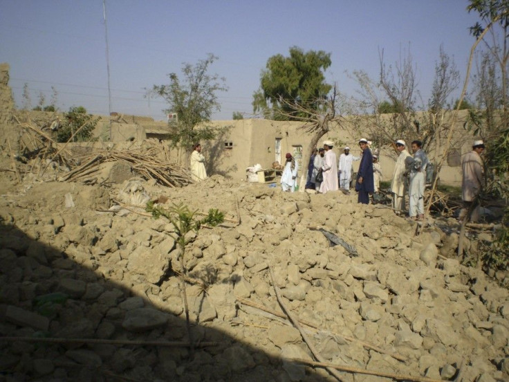 Tribesmen gather at a site of a missile attack on the outskirts of Miranshah
