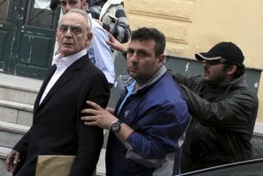 Former socialist minister Akis Tsohatzopoulos ,72, is escorted by plainclothes policemen as he is led to jail in Athens