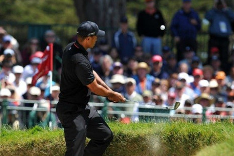 Tiger Woods pops a nearly impossible shot off the lip of a bunker on 6.