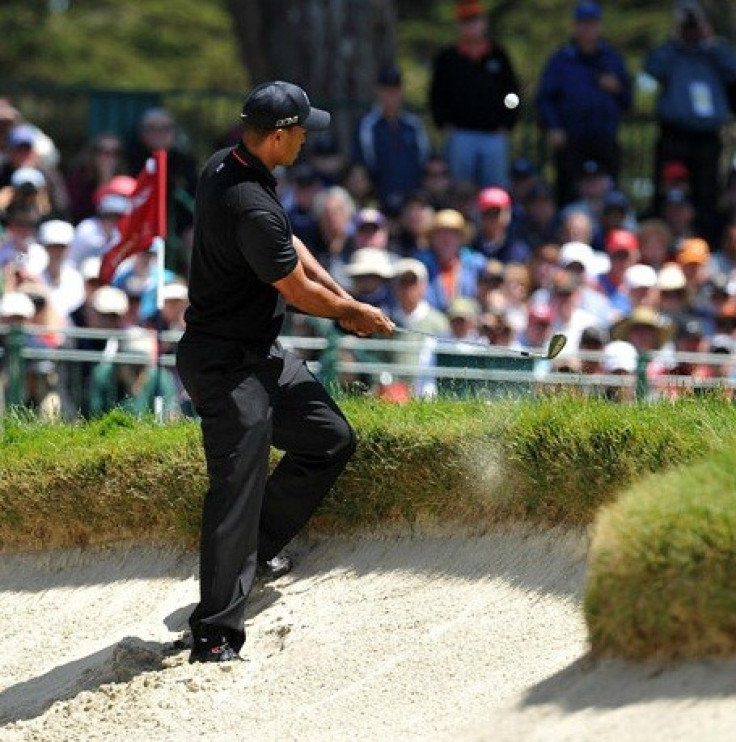 Tiger Woods pops a nearly impossible shot off the lip of a bunker on 6.