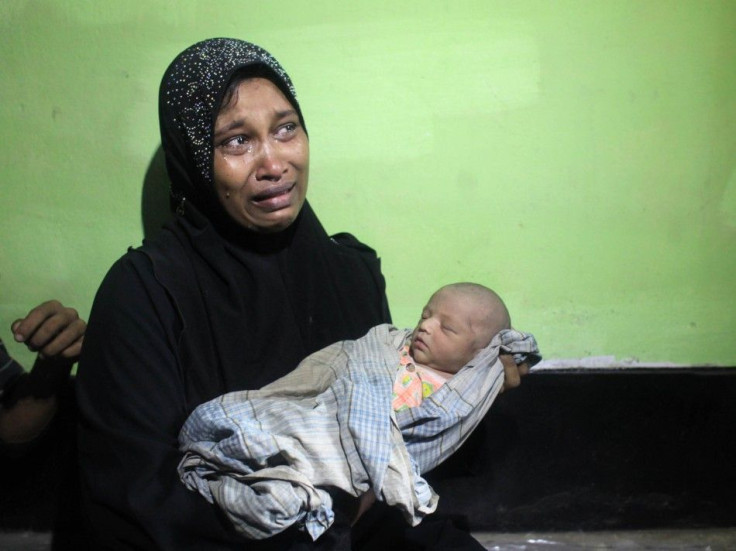 Amena Akter, a Rohingya from Myanmar, cries as she holds her 6-day-old son, Sangram, in the office of the Bangladesh Coast guard in Teknaf