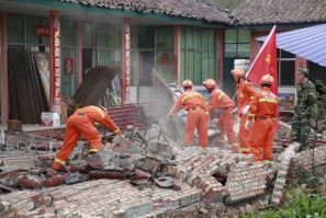 Firemen clean up debris at a factory which was damaged by an earthquake in Ninglang county