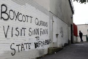 A man walks past graffitti painted on a wall in a nationalist area of north Belfast during Britain&#039;s Queen Elizabeth&#039;s two day tour of Northern Ireland