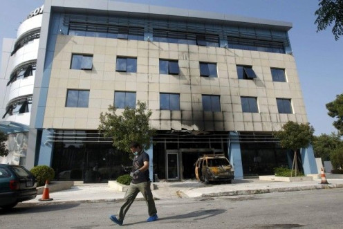 A police investigator searches for evidence following attack on Microsoft&#039;s offices at Marousi suburb north of Athens.