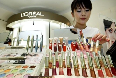 A beauty consultant adjusts cosmetics displayed at L'Oreal Paris' counter at a department store in Tokyo
