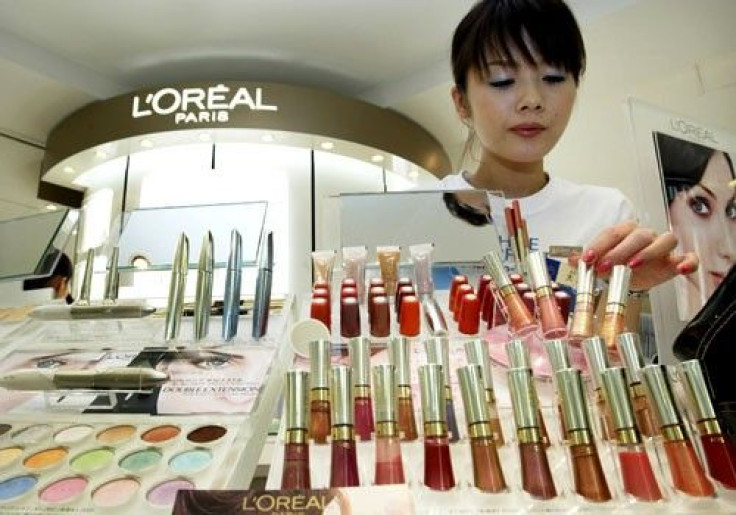 A beauty consultant adjusts cosmetics displayed at L'Oreal Paris' counter at a department store in Tokyo