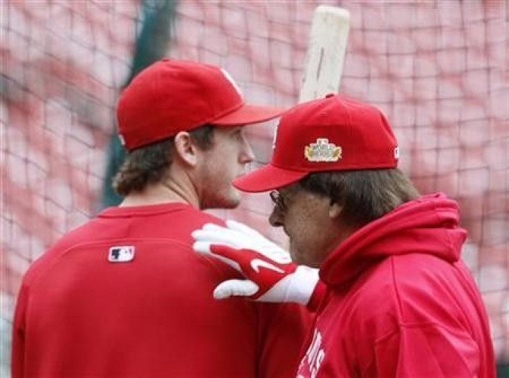 St. Louis Cardinals third baseman David Freese (L) gets a pat on the back from manager Tony La Russa during practice in St. Louis, Missouri