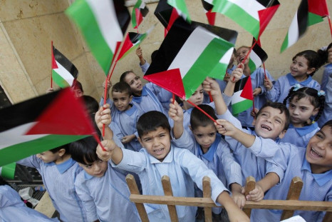 Palestinian children wave their national flags at the Burj al-Barajneh refugee camp in Beirut