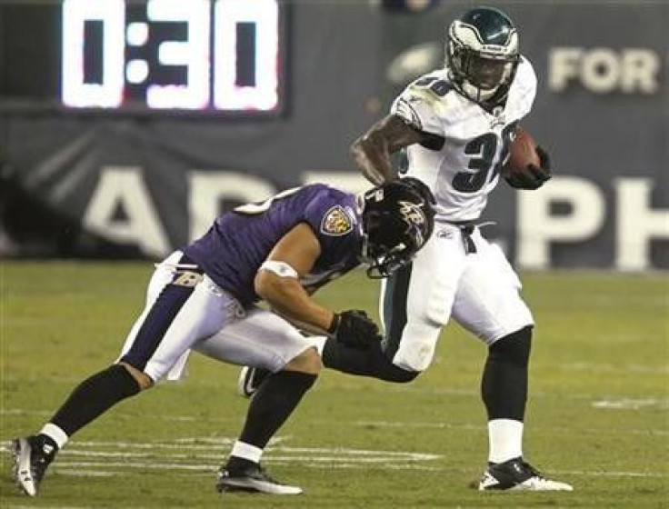 Philadelphia Eagles running back Ronnie Brown (R) avoids the grasp of the Baltimore Ravens safety Haruki Nakamura (L) during the first quarter of NFL preseason football action in Philadelphia, Pennsylvania