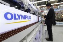 A man looks at Olympus digital cameras at an electronics store in Tokyo