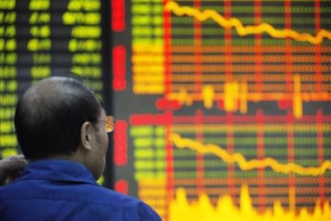 An investor looks at an electronic board showing stock information at a brokerage house in Huaibei