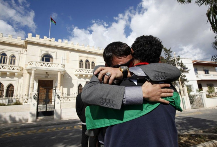 Libyan nationals in Malta embrace after hearing news that Libyan leader Muammar Gaddafi has been killed in Sirte, outside their embassy in Balzan