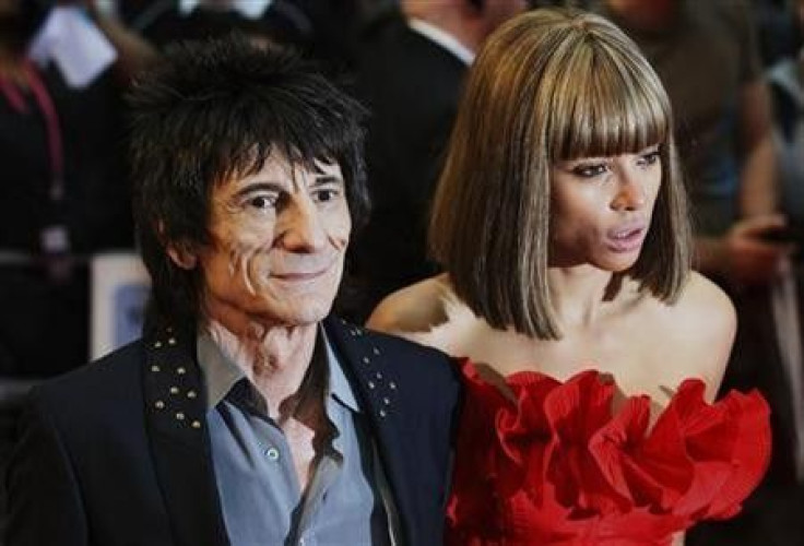Rolling Stones guitarist Ronnie Wood and Ana Araujo pose for photographers as they arrive for the world premiere of the film Larry Crowne at Westfield in west London