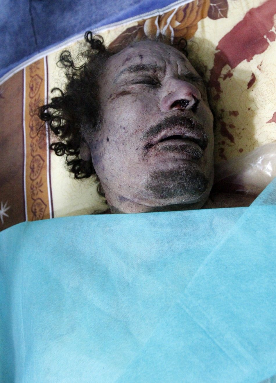 The body of Muammar Gaddafi is seen at a house in Misrata October 20, 2011