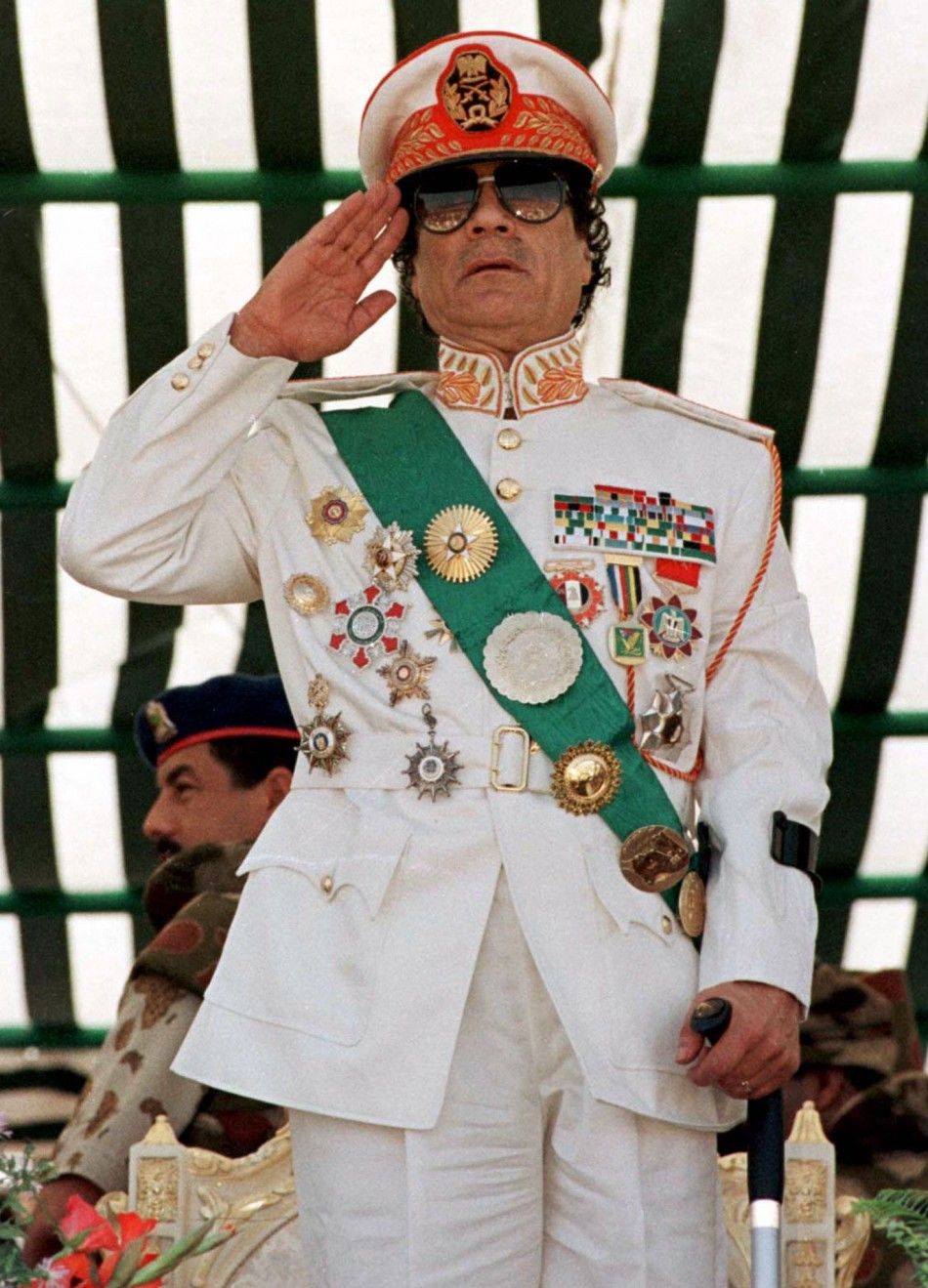 Muammar Gaddafi salutes his armed forces during a parade in Tripoli in 1999