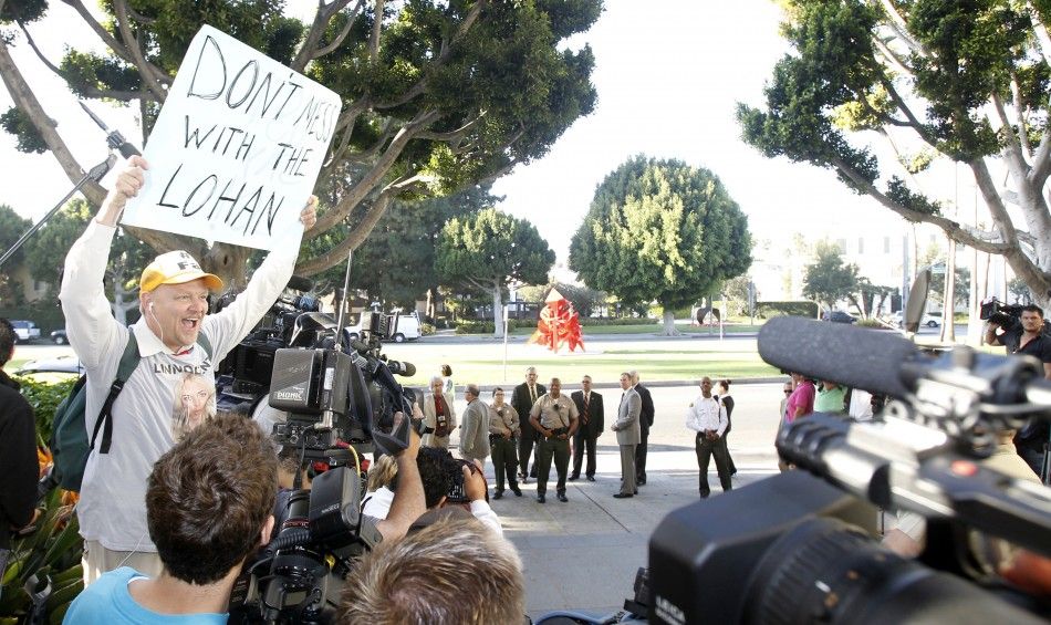 A man holds up a sign as he waits for actress Lindsay Lohan outside the Beverly Hills Courthouse for the actress mandatory appearance in Beverly Hills