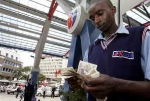 A petrol attendant counts cash at a petrol station in Kenya