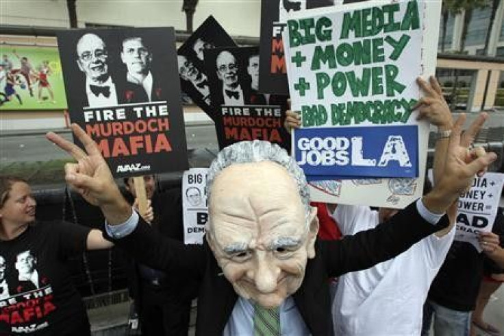 Brent Olson wears a puppet head representation of Rupert Murdoch as protesters demonstrate at Fox Studios during the annual News Corp. stockholder meeting in Los Angeles, California