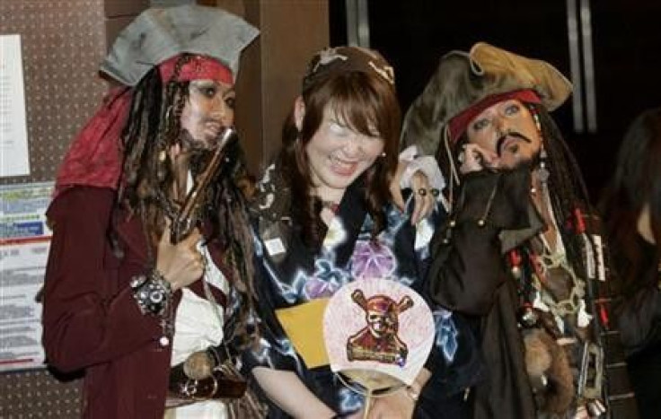 A woman takes a picture with participants who are dressed as ''Captain Jack Sparrow'', a character from ''Pirates of the Caribbean: At World's End'', at a costume event to promote the movie in Tokyo