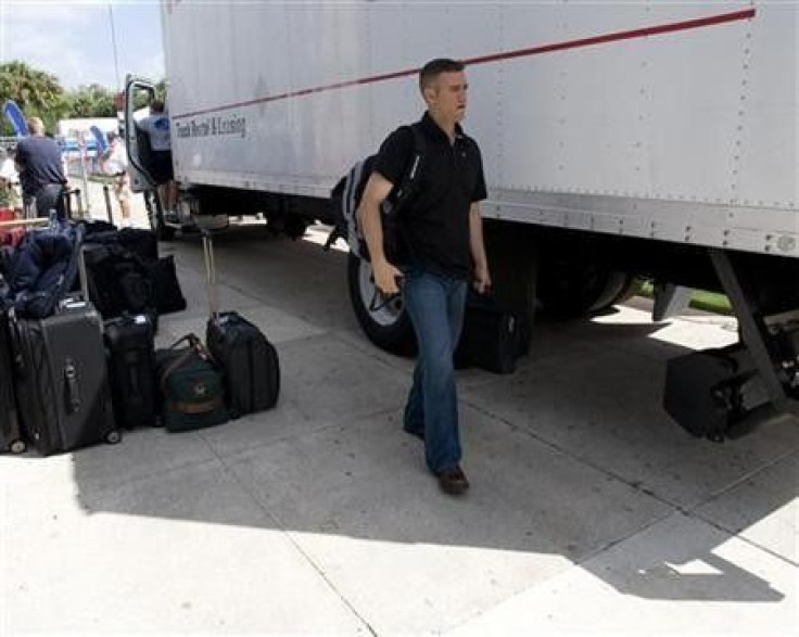 Theo Epstein walks by a van loaded with luggage in Fort Myers, Florida